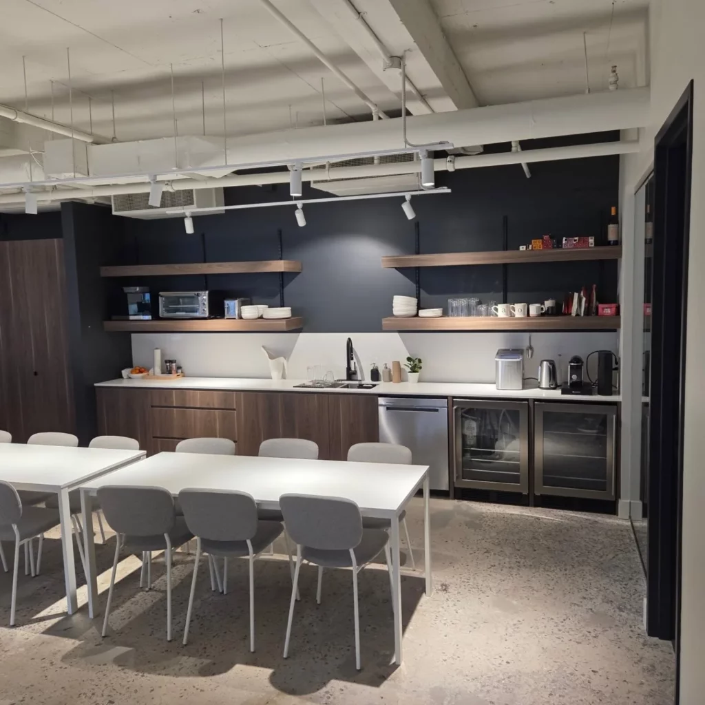 Office kitchen with under-cabinet and pendant lighting at 2100 Drummond