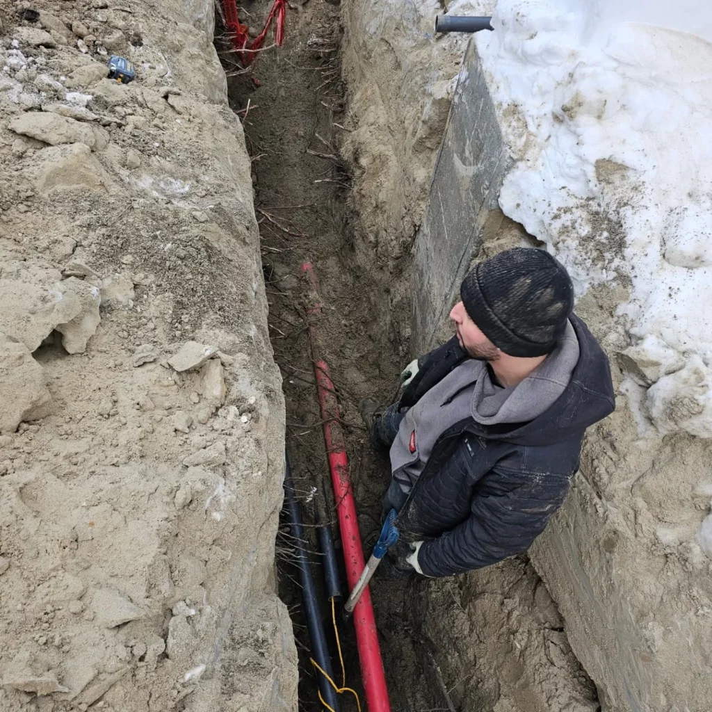 Electrician pulling cables for an underground service entrance in Blainville