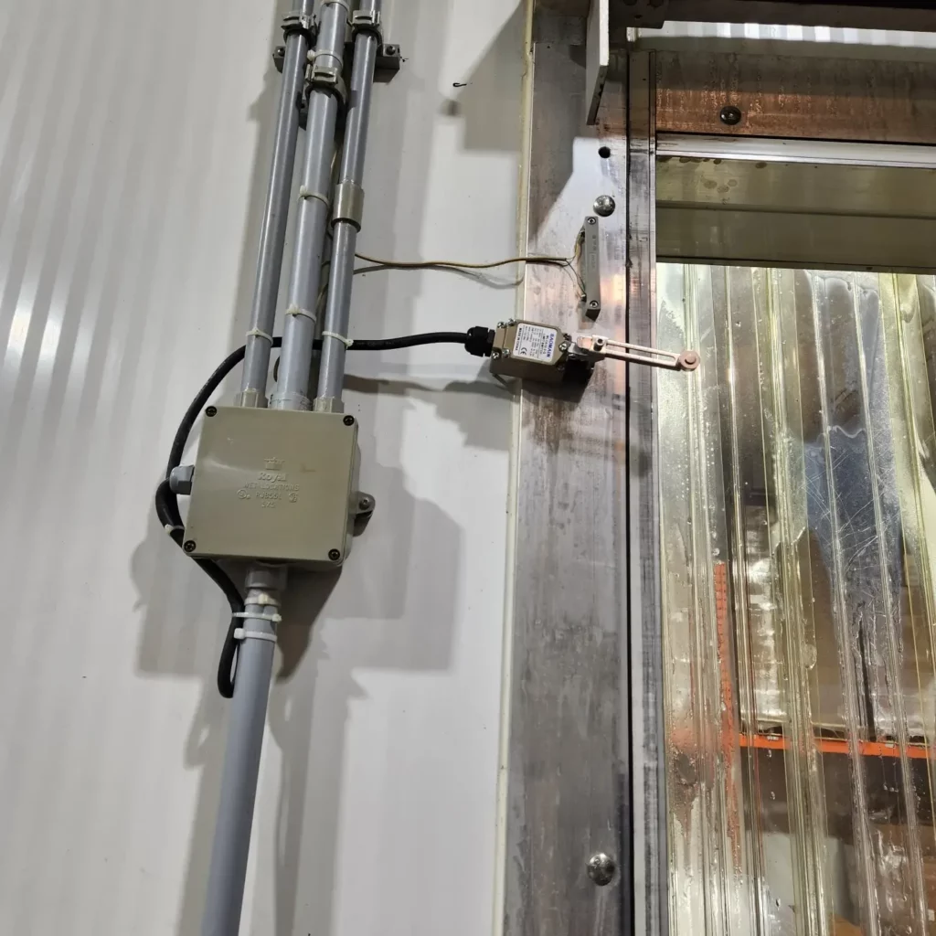 Limit switch and conduit added to an industrial freezer door