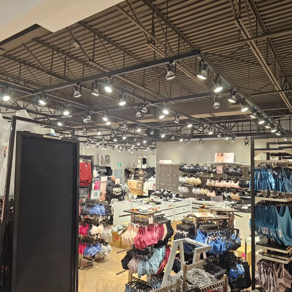 Plafond ouvert avec nouveaux luminaires suspendus et sur rail chez La Vie en Rose Carrefour Richelieu